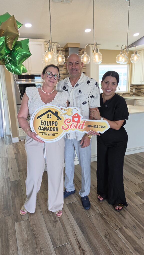 Clientes de Yailyn Homes celebrando en su nueva casa con el cartel de vendido